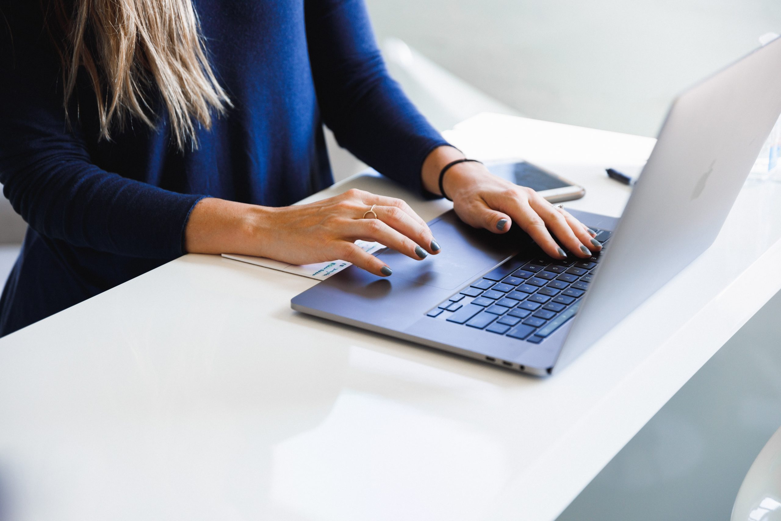 Woman typing at laptop keyboard